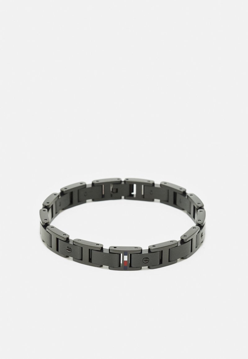 Bracelet à maillons en métal noir avec des segments rectangulaires et de petites vis décoratives, comportant un petit détail rayé coloré sur un maillon.
