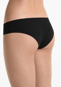 Fekete bikini alsó sima, rugalmas anyagból, alacsony derekú kialakítással és minimális fedezettel, egyszínű kivitelben.