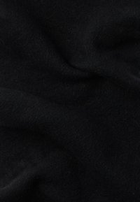 Tecido de lã preto com textura suave, apresentando ondulações subtis e acabamento mate, refletindo a luz com um ligeiro brilho.