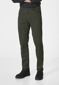 Olive green pants made of cotton blend fabric, featuring a straight cut, five pockets, and button closure. Paired with black footwear.