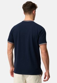 Mørkeblå bomulds T-shirt med rund hals og kontrasterende stribede detaljer på ærmerne. Har en lige kant og korte ærmer.