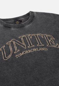 Grijze sweatshirt met een ronde hals, zachte textuur en contrasterende beige geborduurde tekst met de tekst "UNITE TOMORROWLAND."
