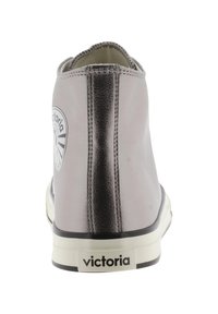 Zapatilla gris de media altura con acabado de cuero brillante, talón negro en contraste, suela blanca y detalle de logo circular en el lado exterior.