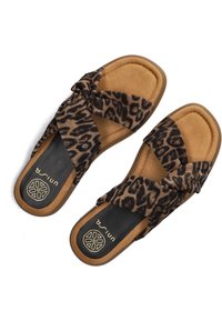 Leopard print cross-strap sandals with a soft tan cork-like sole and black footbed, featuring a logo detail on the footbed.