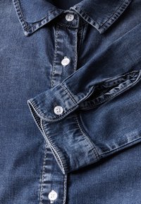 Donkerblauw denim shirt met een klassieke kraag, witte knopen en contrasterende stiksels; gladde textuur met een subtiele glans.