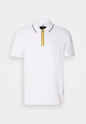 Polo bianco con maniche corte, caratterizzato da una zip gialla e bordi neri lungo il colletto. Testurizzato con un logo sottile sul petto.