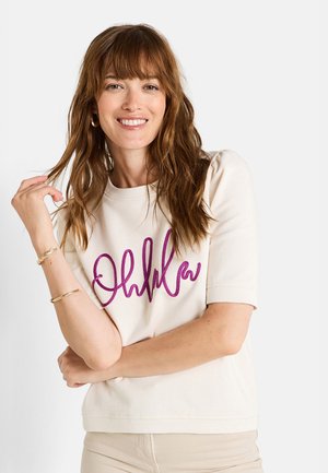Sudadera de manga corta en color crema con un audaz texto bordado en púrpura "Ohlala" en el frente, con un corte relajado y puños acanalados.