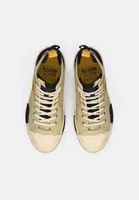 Μπεζ πάνινα αθλητικά με μαύρες λεπτομέρειες και κίτρινες αποχρώσεις. Παχιά κρέμ λαστιχένια σόλα, επίπεδα λευκά κορδόνια και υφασμάτινο πάνω μέρος.