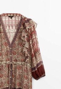 Robe imprimée avec un décolleté en V, des manches volantes et une fermeture à boutons sur le devant. Présente des motifs floraux dans des tons rouges et beiges avec des designs complexes.