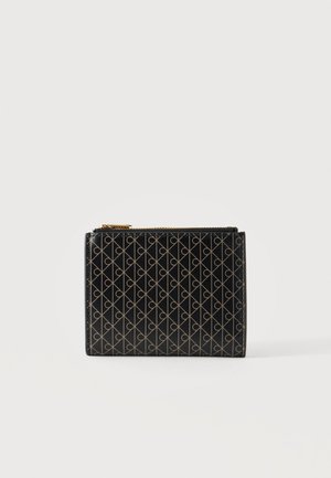Portafoglio nero con motivo geometrico beige e cerniera dorata nella parte superiore, mostrato su uno sfondo chiaro e uniforme.