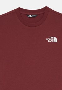 Bordo īsā piedurkņu T-krekls kokvilnas maisījumā ar apaļu kakla izgriezumu. Ar balto "The North Face" logo kreisajā krūtīs. Mīksta tekstūra.