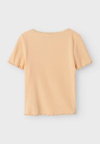  ferskenfarvet ribbet t-shirt med korte ærmer og bølgede kanter. Har en rund halsudskæring og blødt, tekstureret stof.