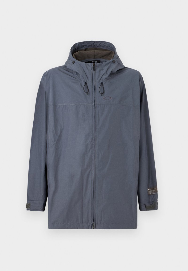 Grijze windbreakerjas met capuchon, rits aan de voorkant, elastische manchetten en een structuurinterieur. Heeft trekkoorden bij de capuchon en een logo-detail.