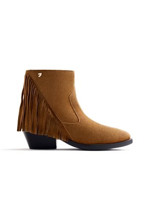 Brown suede ankle boot with a block heel, featuring side fringes, an elastic side panel, and a decorative logo accent.
