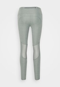 Leggings gris clair avec un motif texturé, dotés de panneaux en maille au niveau des cuisses et d'une poche zippée discrète à la taille.