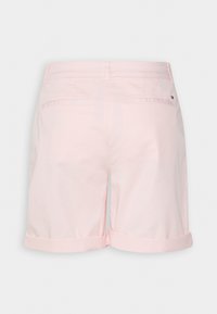Pantalones cortos de algodón de color rosa claro con un diseño de puños doblados, que cuentan con dos bolsillos traseros y un pequeño logo cerca de la pretina.