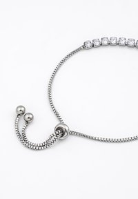 Adjustable silver-colored necklace featuring a smooth chain and multiple faceted clear gemstones, secured with a sliding fastener.