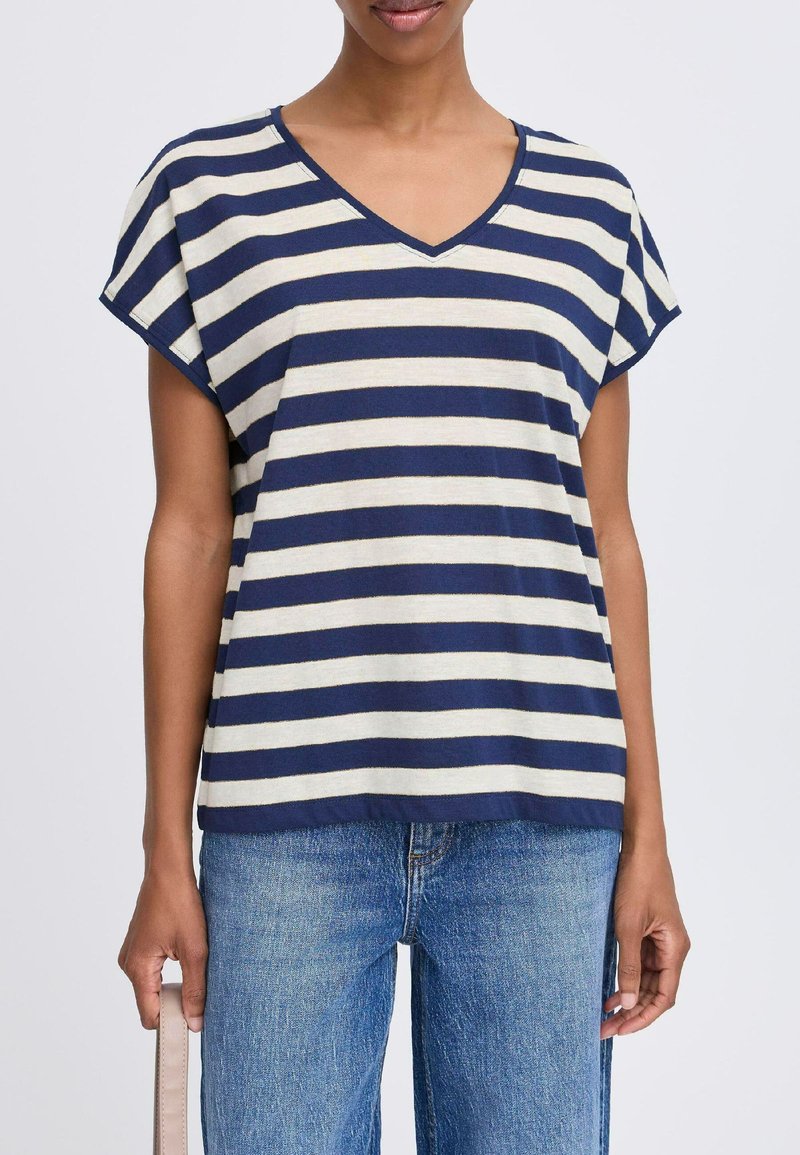Camiseta de rayas en azul marino y crema con escote en V y mangas cortas, confeccionada con tejido suave. Presenta un corte holgado, acentuando el uso casual.
