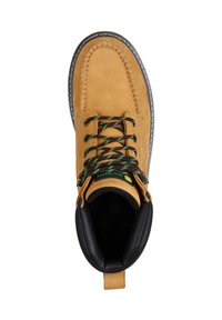 Bota de trabajo de cuero marrón con cordones, con un cuello acolchado negro y cordones en un patrón negro-verde-amarillo, vista desde arriba sobre un fondo blanco.