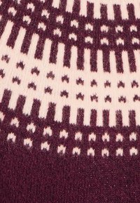 Maglione lavorato a maglia con una combinazione di colori bordeaux e crema, impreziosito da motivi geometrici, tessuto texturizzato e sottili accenti di brillantezza.