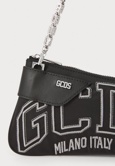Pungă din material textil negru cu accente argintii, având brodat "GCDS" și "MILANO ITALY" în gri, cu închidere tip fermoar și curea decorativă cu lănțișor.