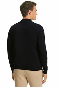 Navyblauer Pullover mit langen Ärmeln, Rundhalsausschnitt und glattem Strickmuster, auf einem Modell von hinten sichtbar.