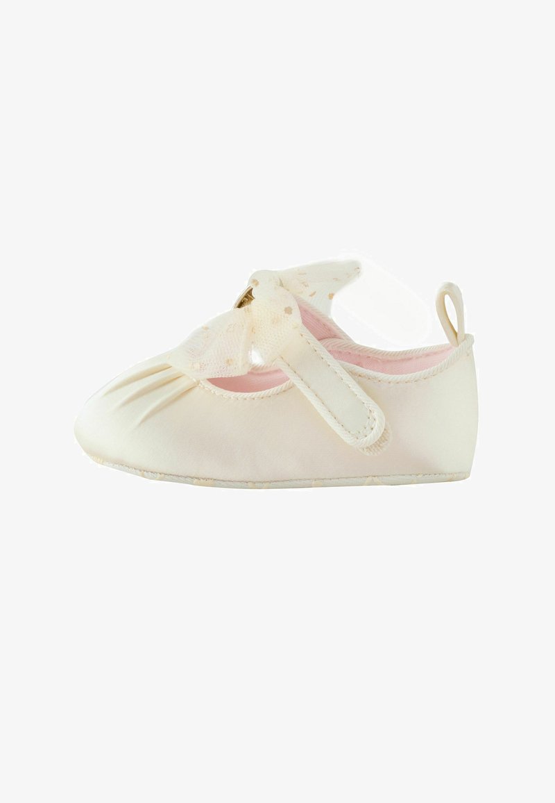 Chaussure souple pour bébé de couleur crème avec intérieur rose, dotée d'une bride en Velcro et d'un nœud décoratif en organza à pois dorés.