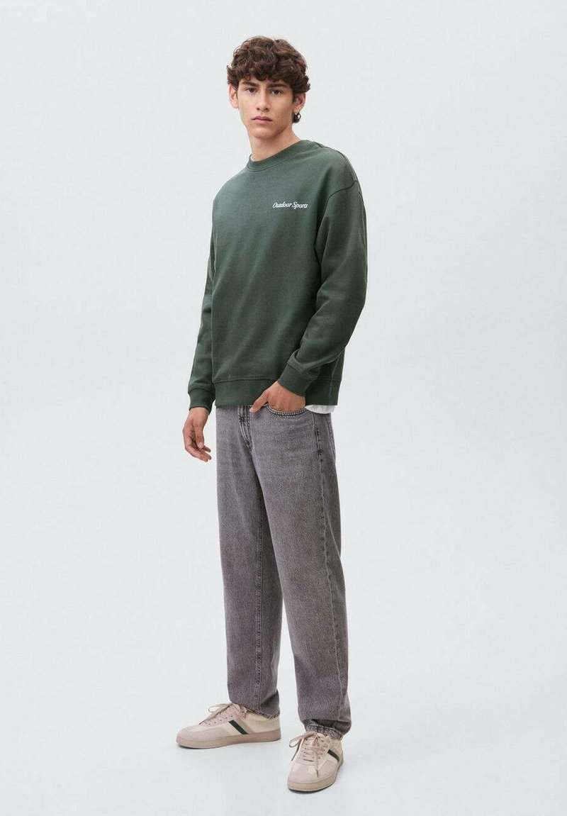 FELPA verde con una vestibilità comoda, scollo rotondo e dettaglio logo bianco. Abbinata a jeans in denim grigio chiaro, a vestibilità ampia, e sneakers color crema.