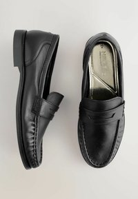 Mocasini negri din piele cu finisaj neted, vârf rotund, detalii cusute și o bretea decorativă pe partea din față. Talpă plată din cauciuc.