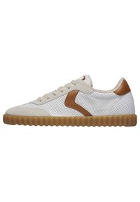 Białe perforowane sneakersy z brązowymi zamszowymi akcentami, z teksturowaną gumową podeszwą i płaskimi sznurowadłami. Okrągły czubek i niski profil.