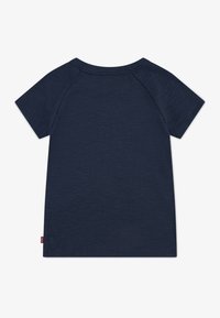 Marineblauwe t-shirt met korte mouwen en ronde hals, met een subtiele ribbelstructuur en een klein rood etiket aan de onderkant van de linkerkant.