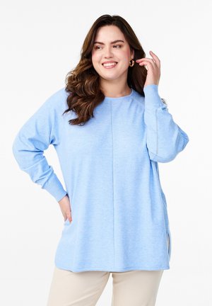 Light blue sweatshirt made of soft fabric. Features a round neckline, long sleeves, side slits, and a straight-cut hem with seam detailing.