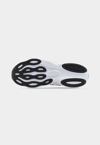 Σόλα λευκού αθλητικού παπουτσιού με μαύρες, οβάλ λαστιχένιες λαβές και κυματιστά μοτίβα πέλματος για βελτιωμένη πρόσφυση.