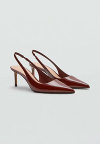 Pantofi cu toc slingback din piele maro, cu vârf ascuțit, finisaj lucios și toc subțire, înalt. Prezintă un design cu decupaje pe laterale.