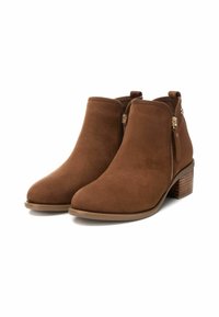 Stivali alla caviglia in suede marrone con punta affusolata e tacco spesso. Presentano zip laterali doppie e un dettaglio di cucitura sul tacco.