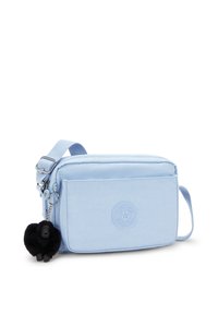 Borsa crossbody blu chiaro realizzata in tessuto morbido, con chiusura a zip, tracolla regolabile e un charm peloso nero. Include un dettaglio logo impresso.