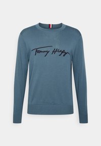 Maglione blu in morbido tessuto, con collo a giro e maniche lunghe, dotato di ricamo del logo "Tommy Hilfiger" sul petto.