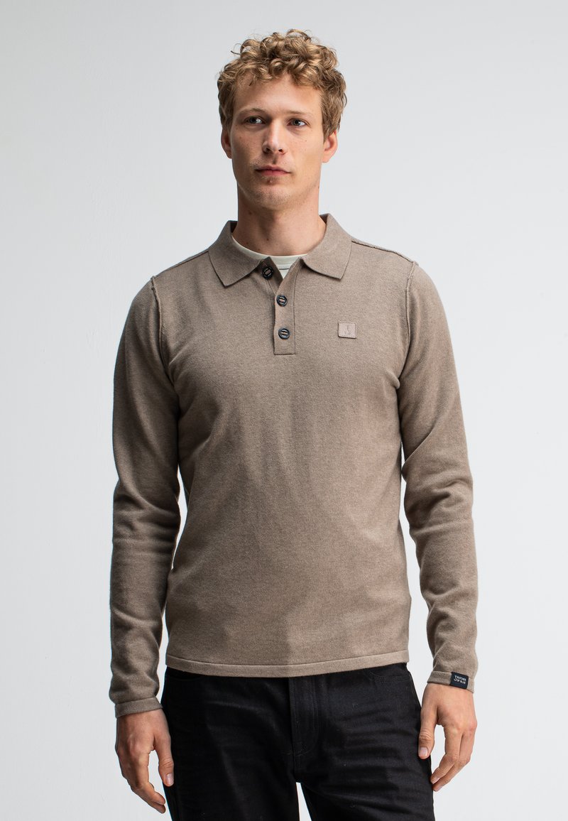 Langärmliges, beiges Poloshirt aus Strickstoff. Verfügt über einen Kragen, eine Drei-Knopf-Leiste, ein kleines Logopatch und gerippte Bündchen.
