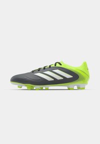 Schwarze und neongrüne Fußballschuhe mit einer strukturierten Oberseite, weißen Streifenakzenten und einer genoppten Gummisohle für besseren Halt.