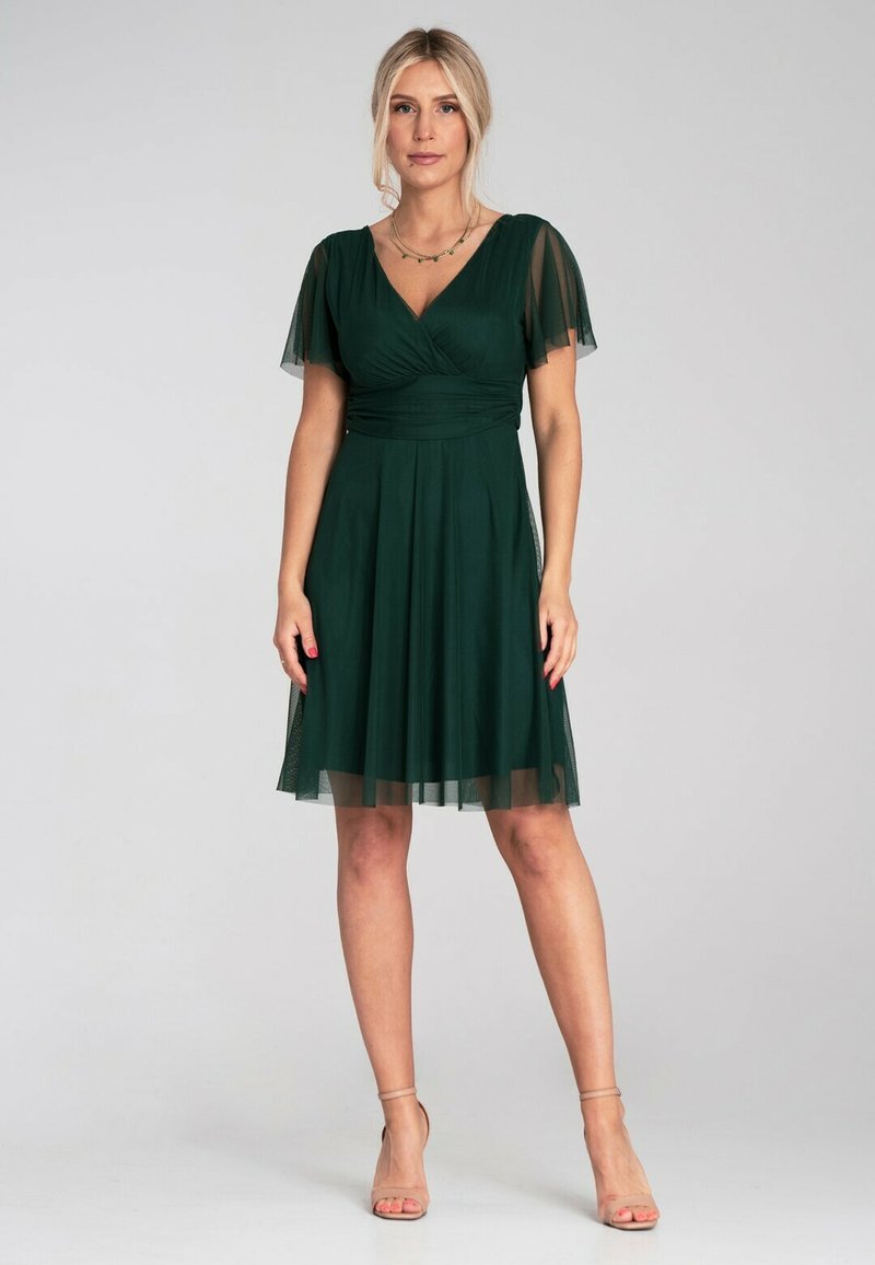 Grünes Kleid mit kurzen, transparenten Ärmeln, einem Wickel-V-Ausschnitt und einem fließenden A-Linien-Rock. Weicher Stoff mit einem leichten, strukturierten Aussehen.