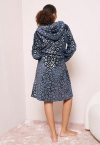 Robe da bagno con cappuccio in blu navy con stampa leopardata argentata. Texture morbida, design di lunghezza media, vita con cintura e maniche lunghe.