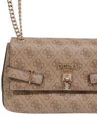 Bolso beige con estampado, correa de cadena, herrajes dorados y cierre frontal. Presenta una tela texturizada y detalle de logo.