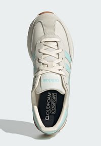 Biela teniska so sivými semišovými prvkami a pruhmi v mäta zelenej farbe. Má okrúhlu špičku, šnurovací dizajn a stielku "CLOUDFOAM COMFORT".