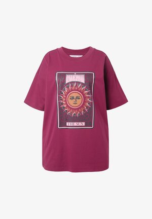 Lila übergroße T-Shirt mit einem grafischen Tarot-Karte, die ein Sonnen Gesicht, Flammen und den Text "DIE SONNE" unter dem Bild zeigt.