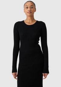 Zwart geribbeld longsleeve shirt met een ronde halslijn. De stof is gestructureerd en aansluitend op het lichaam, met lange mouwen die tot aan de pols reiken en een lichte flare hebben.