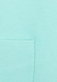 Mintgrüner Sweatshirtstoff mit glatter Textur und gerippten Akzenten. Verfügt über eine Kängurutasche und ein einheitliches Strickmuster.
