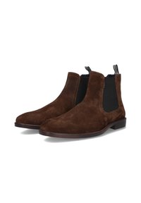 Bottes Chelsea en daim marron avec des panneaux élastiques noirs sur les côtés, un bout arrondi et un talon bas empilé. Présente des languettes rayées à l'arrière.