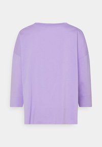 T-shirt di cotone morbido viola chiaro con maniche a tre quarti, colletto rotondo e vestibilità ampia e rilassata.