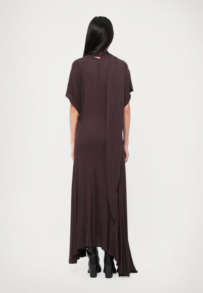 Long, dark brown dress featuring short sleeves, a draped back, and a high-low hemline. Made from a smooth, lightweight fabric.