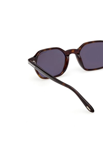 Sluneční brýle ve tvaru želvoviny s geometrickým, kulatým rámem; tmavě fialové čočky; štíhlé nožičky se železným detailem na závěsu.